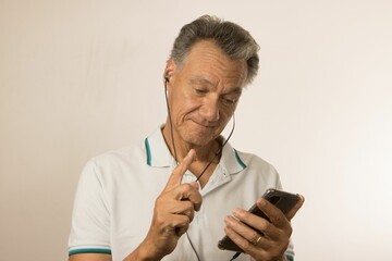 Man listening to music or a podcast using ear buds on his smartphone