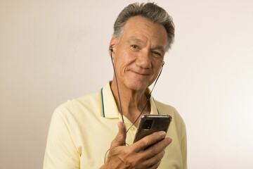 Man listening to music or a podcast using ear buds on his smartphone