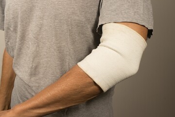 Man wearing an elastic type ace bandage on his elbow for pain relief