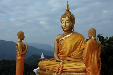 Aerial view of big golden Buddha statues on the top of a mountain