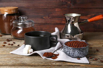 Bowl of coffee powder, sugar and cup on wooden table, closeup