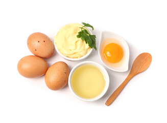 Bowl with tasty mayonnaise sauce and ingredients on white background
