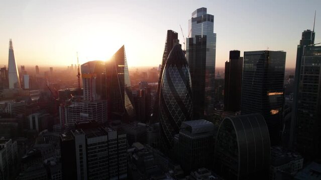  Evening shot of futuristic downtown skyscrapers against romantic sunset sky. Fly around City business hub. London, UK