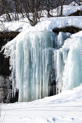 Gefrorenes Wasser - Vereisungen mit Eiszapfen an einer Felswand