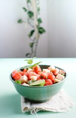 Vertical shot of a watermelon salad with a lime in a bowl
