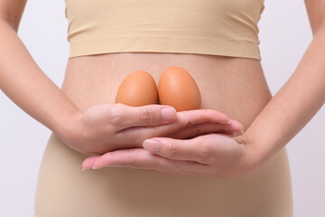 Close up woman holding eggs on belly , prepare reproductive fertility , Ovulation stimulation , matherinty concept
