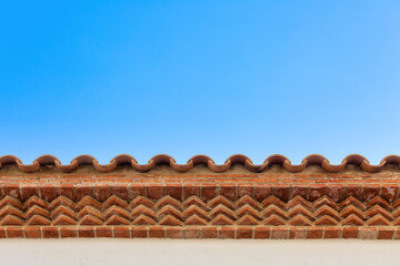 Beautiful Spanish-style Brickwork on Overhanging Roof against Blue Sky for backgrounds, textures, and presentations