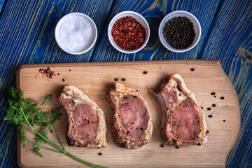Raw pork meat on a cutting board and spices.top view