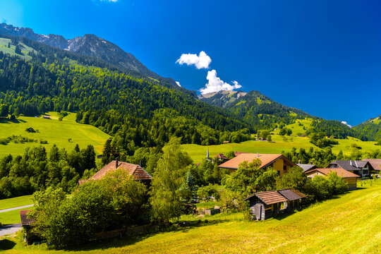 Cottages houses and mountains covered with forest in the village Darstetten in Frutigen-Niedersimmental, Bern, Switzerland