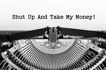 Shut Up And Take My Money phrase closeup being typing and centered on a sheet of paper on old vintage typewriter mechanical