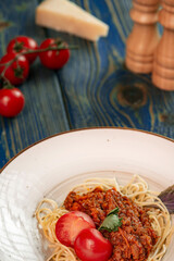 italian Pasta bolognese with meat, tomato sauce and vegetables in blue wooden desk .