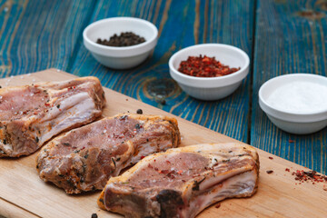 Raw pork meat on a cutting board and spices.
