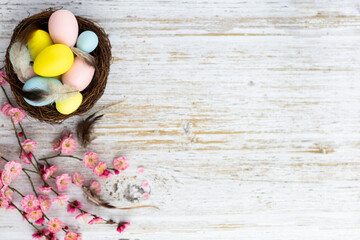 Obraz na płótnie Canvas Stylish background with colorful easter eggs on white wooden background with copy space