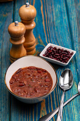 bean soup, salt and pepper on blue wooden background
