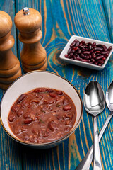bean soup, salt and pepper on blue wooden background