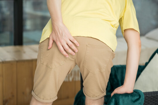 Hemorrhoidal pain, man suffering from hemorrhoids at home