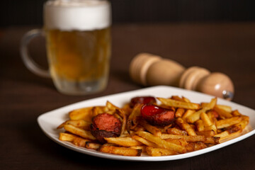 Potatoes with sausages, cut into slices and fried in oil, in rustic style. Fried potatoes with sausage on a plate