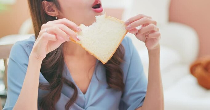 asian woman biting toast happily