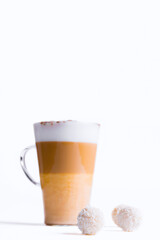 Latte macchiato in a tall glass on a white background. Cafe latte layered with milk in a high drinking glass. Minimalism. Сopy space