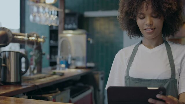 Young female waitress checking orders on the tablet