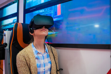 Woman using black virtual reality headset, looking around and playing in passenger of public...