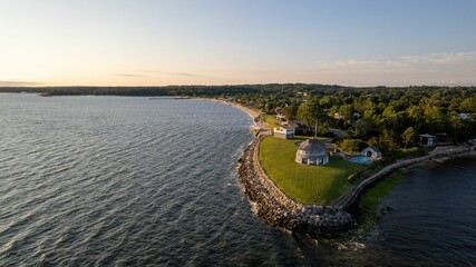 Aerial view of sunrise on island with green lawn and resort houses of Long Island, New York © Audley C Bullock/Wirestock Creators