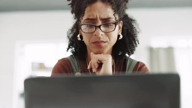 Laptop, stress and doubt with a business woman in her office, reading an email while feeling confused. Computer, glasses and worry with a female employee thinking while typing a proposal at work