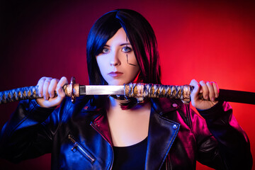 Portrait of a young woman with a bob hairstyle in a black leather jacket with a katana in her hands posing isolated on a dark background with red backlights, cyberpunk concept. © Михаил Гута