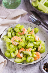 Shrimps and chopped celery in a vegetarian vitamin salad for an antioxidant diet on a plate vertical view