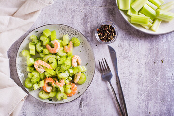 Fresh salad of celery and shrimp on a plate for a vegetarian diet top view