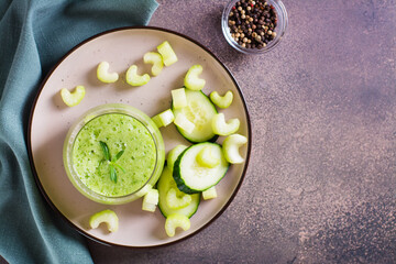 Fresh green cucumber and celery smoothie in glass for vegetarian diet top view