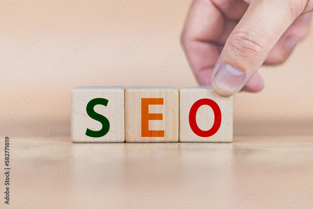 Wall mural search engine optimization concept man's hand is building a cube wood to search for information on t