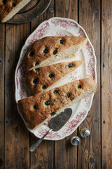 focaccia with olives and rosemary on a platter on a wooden table