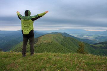 Hiker is standing and blessing , on background mountain Osnica , Mala Fatra, Slovakia in spring...