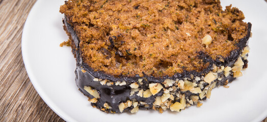 Pastry made of zucchini with nuts and raisin on plate. Delicious dessert