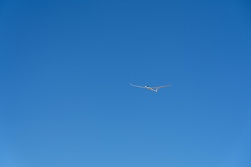 Scenic view of a glider over the mountains against the blue sky