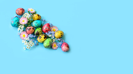 Easter colorful eggs and flowers close up on blue background. symbol of Easter holiday, Ostara. festive decor for spring season. copy space. template for design
