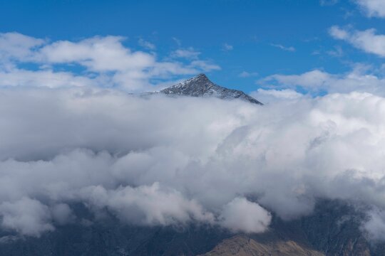 Beautiful view of the peak of the Rocciamelone mountain covered with fluffy clouds
