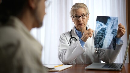 Doctor is shows X-ray images to patient. Concept of doctor discuss personal healthcare.