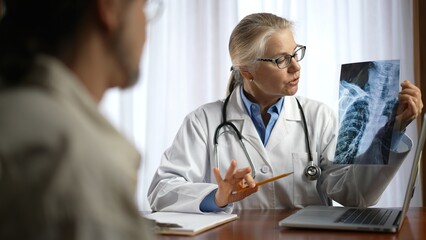 Doctor is shows X-ray images to patient. Concept of doctor discuss personal healthcare.