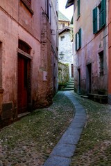 Fototapeta na wymiar Vertical shot of a narrow alley between buildings in Argegno Italy