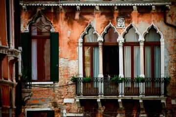 Close-up shot of the windows and balcony of an old house in Venice, Italy