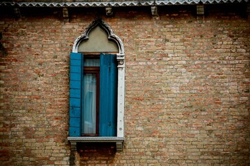 Close-up shot of a window with wooden shutters of an old Venice house, Italy