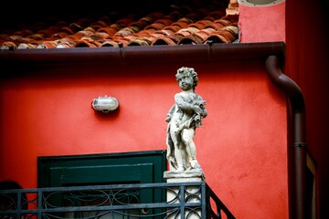 Beautiful shot of a historic sculpture near a red building in Venice, Italy
