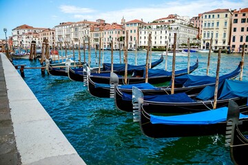 Row of blue covered gondolas moored onto the pier in Venice, Italy