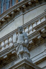 Vertical shot of a historic sculpture near a building in Venice, Italy