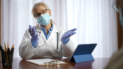 Fototapeta premium Woman doctor greets a patient with handshake in bright modern office in hospital exam room. Concept of helpful doctor.