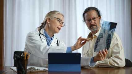 Doctor is shows X-ray images to patient. Concept of doctor discuss personal healthcare solutions.
