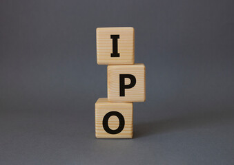 IPO- Initial Public Offering symbol. Concept word IPO on wooden cubes. Beautiful grey background....