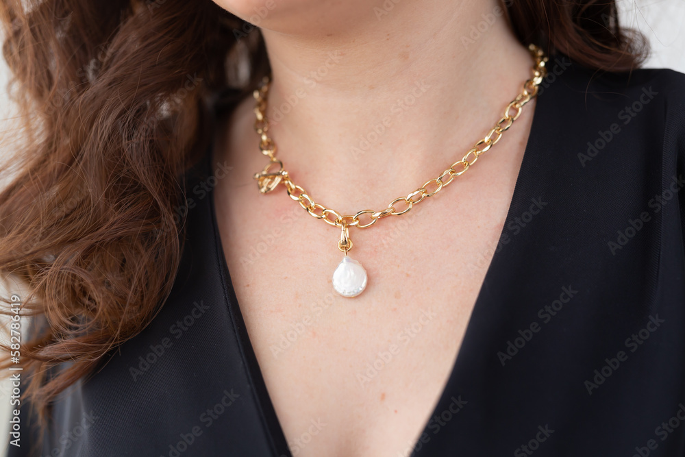 Wall mural close up attractive female model gold necklace and pearl pendant. woman wearing jewellery. jewellery